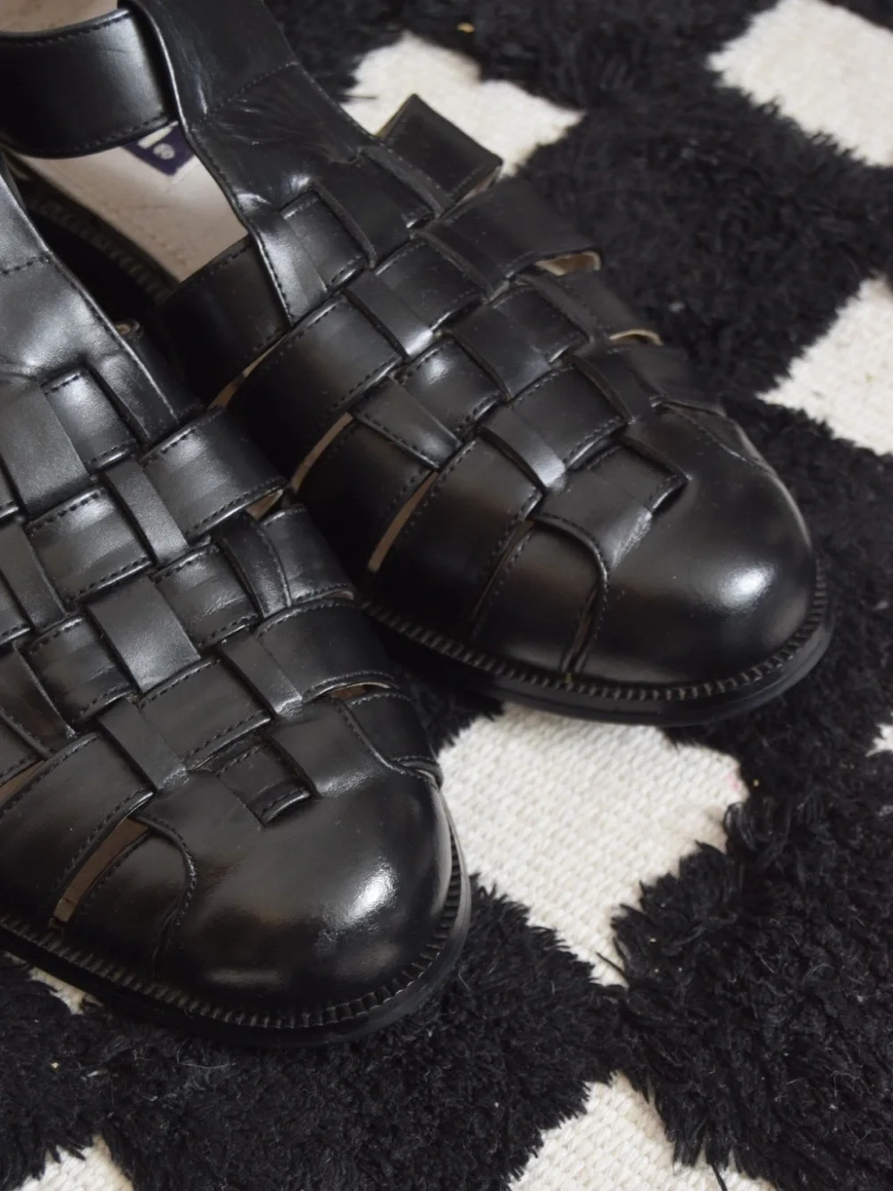 Black leather woven sandals / huaraches with buckle detail.